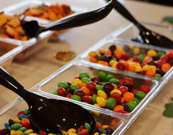 A spoon is in a container of candy.