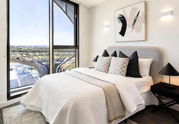 A bedroom with a large bed and a view of the city.