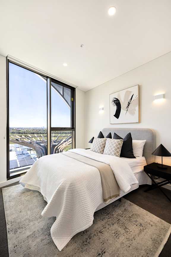 A bedroom with a large bed and a view of the city.