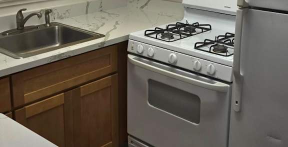 A kitchen with wooden cabinets and a white refrigerator.
