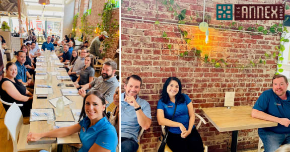 a group of people sitting at tables in front of a brick wall