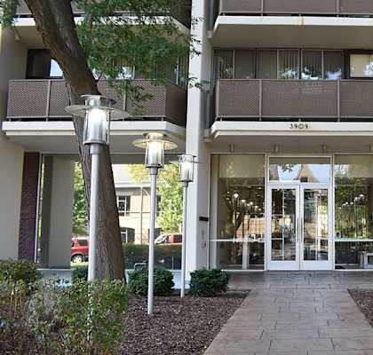 The image shows the front of a building with a glass door entrance and a sign that reads "SID".