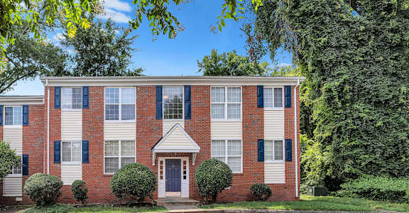 A red brick building with a white door and windows.