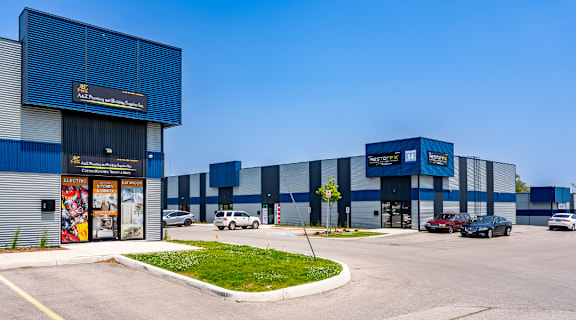 A blue and white industrial building with a clear blue sky in the background.