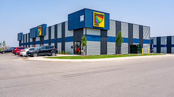 A large industrial building with a blue and yellow sign on the side.