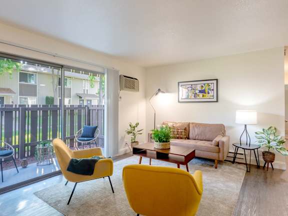A living room with a yellow chair and a couch.