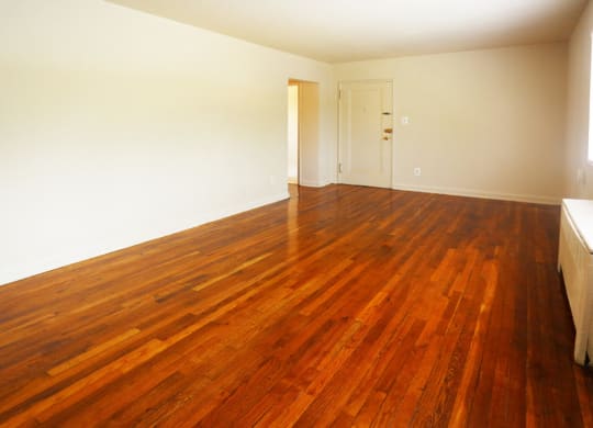 an empty living room with a wooden floor and a door