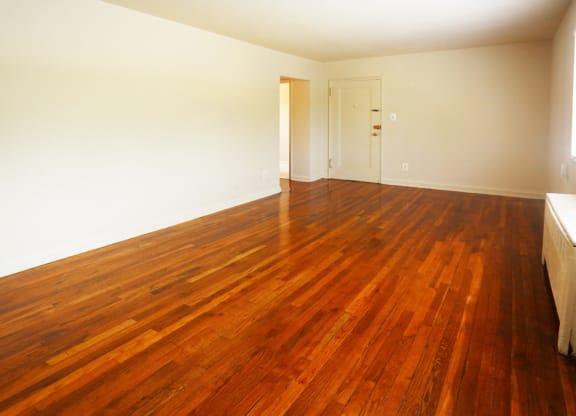 an empty living room with a wooden floor and a door