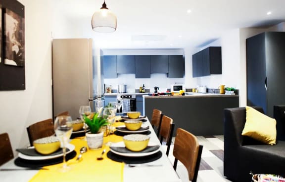 a long dining table with a kitchen in the background