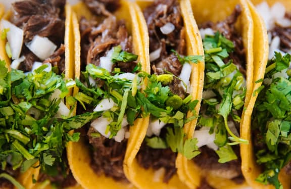 a plate of tacos with meat and toppings