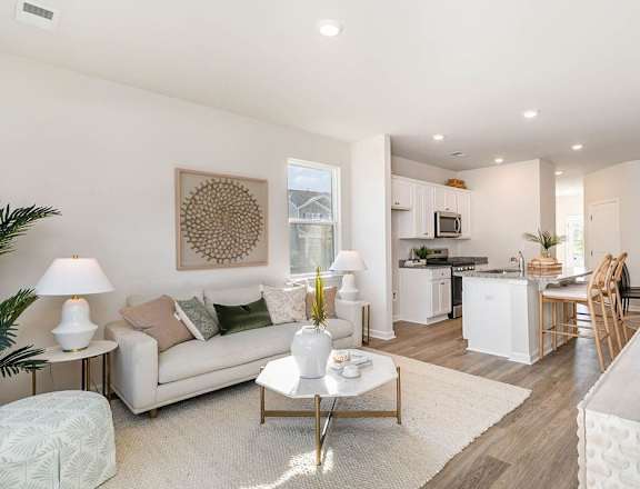 A well-lit, modern living room with a white sofa and a coffee table.