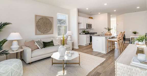A well-lit, modern living room with a white sofa and a coffee table.