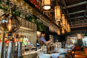 a bartender standing behind the bar at a restaurant