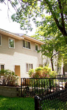 A house with a grey siding and a brown door.