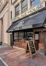 A black sign with white letters reads "Capital Ale House.".