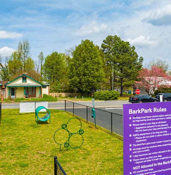 a sign for bath park rules in front of a tennis court