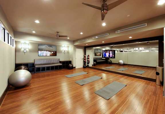 a yoga room with yoga mats and a tv on the wall
