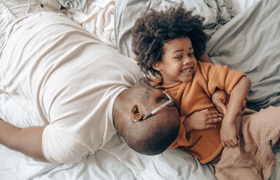 a man and a child laying on a bed
