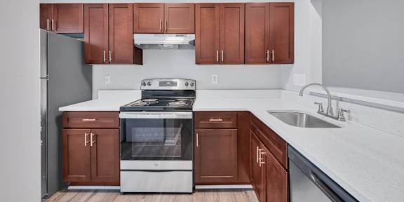 a kitchen with white countertops and dark wood cabinets