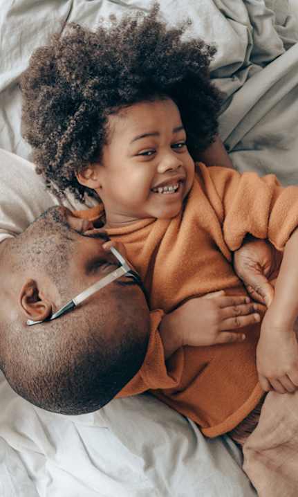 A man and a child are lying on a bed.