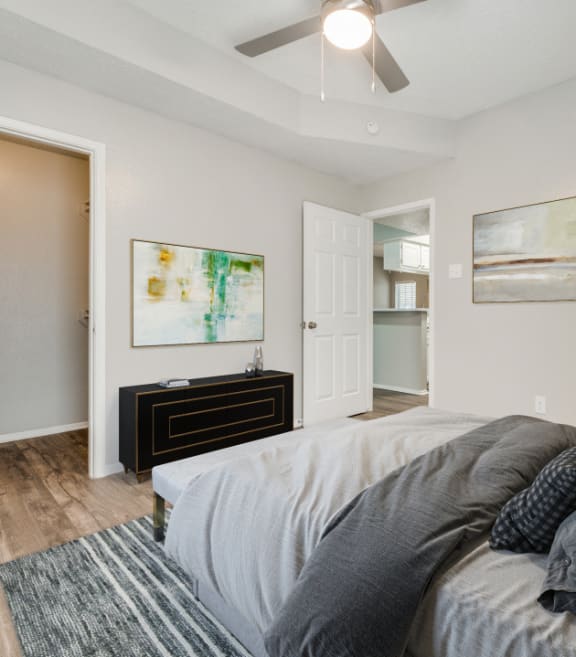 a bedroom with a large bed and a ceiling fan at Foxborough Apartments, Irving, TX