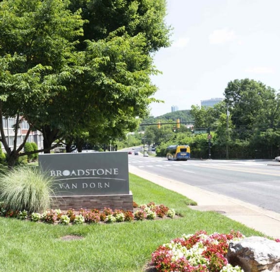 a sign sits in the grass next to a street