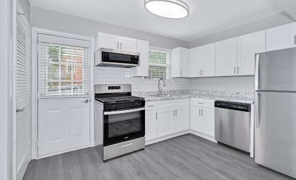 a kitchen with white cabinets and stainless steel appliances
