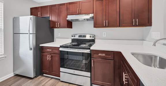 a kitchen with dark wood cabinets and white countertops