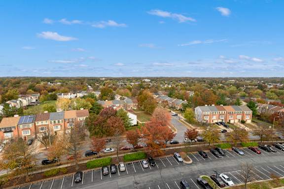 A parking lot with cars and apartment buildings in the background.