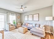 Thumbnail 21 of 34 - a living room with furniture and a ceiling fan at the flats at sundown luxury apartments in north port florida