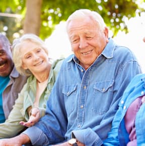 A group of four people sitting together outdoors.