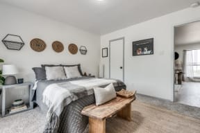 a bedroom with a large bed and a wooden bench at the end of the bed