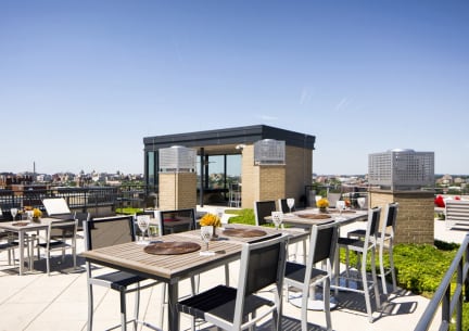 rooftop terrace with tables and chairs and views of the city