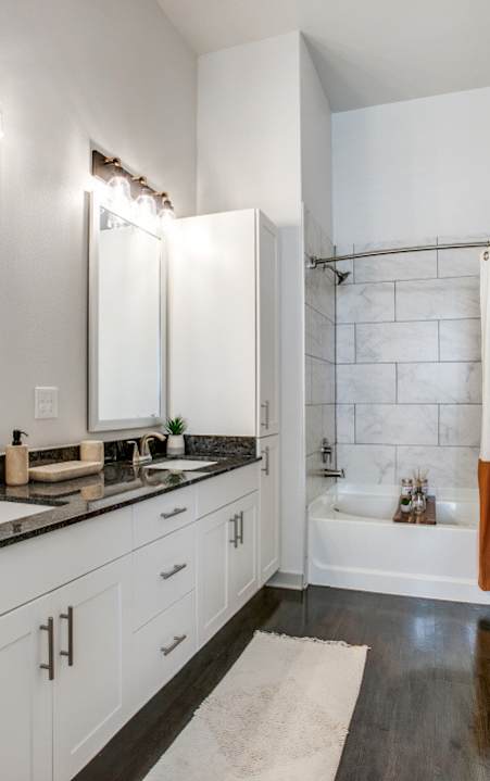a bathroom with a glass shower and a black and white tile floor