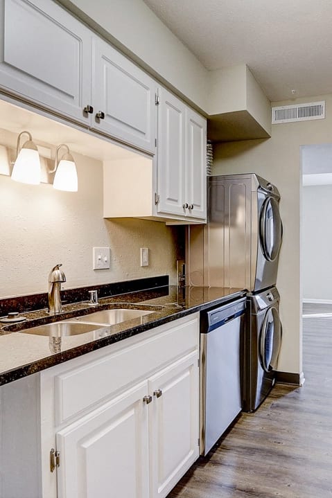 an empty kitchen with white cabinets and stainless steel appliances