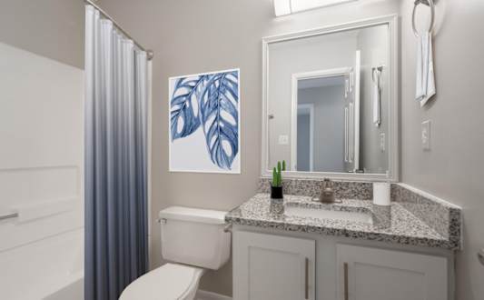 A bathroom with a toilet, sink, and a mirror.