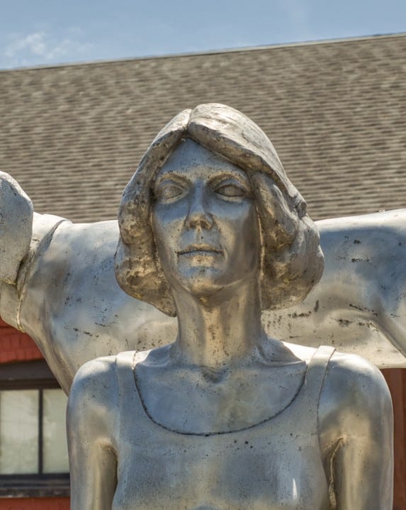 a statue of a woman and a dog in front of a building