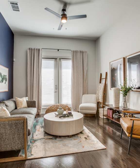 a living room with blue walls and a ceiling fan