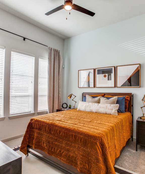 a bedroom with a bed and a ceiling fan