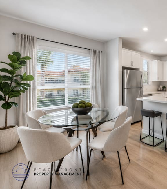 A well-lit, modern kitchen and living room with a dining area.