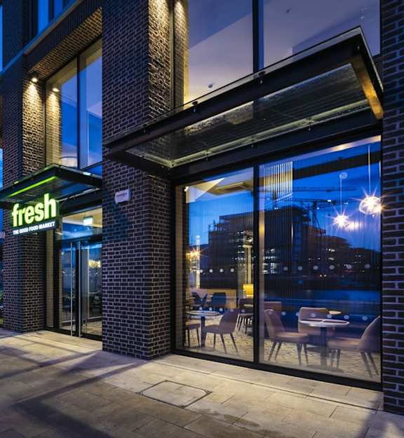 the front of a store with a green sign on a brick building