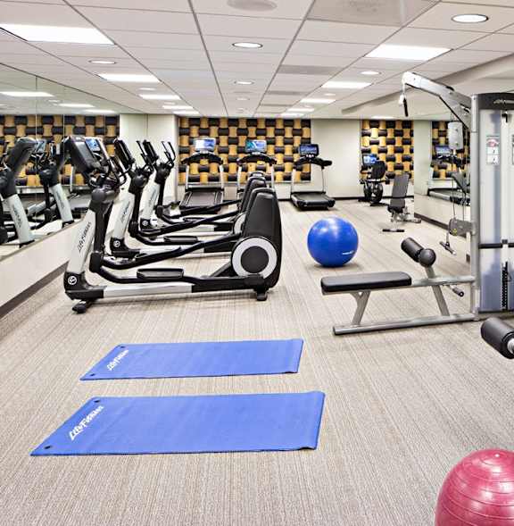 a gym with cardio equipment and weights in the new yorker hotel fitness center