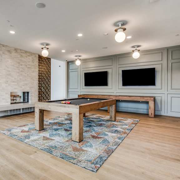 A room with a pool table and a patterned rug.