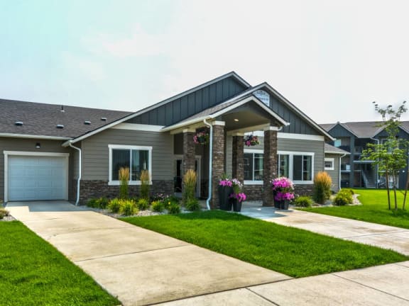 a house with a lawn and a sidewalk in front of it