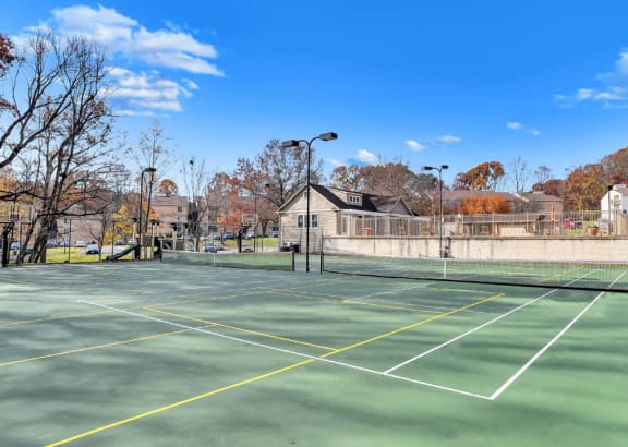 a tennis court with a house in the background