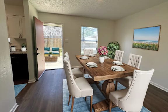 A dining room with a wooden table and chairs.