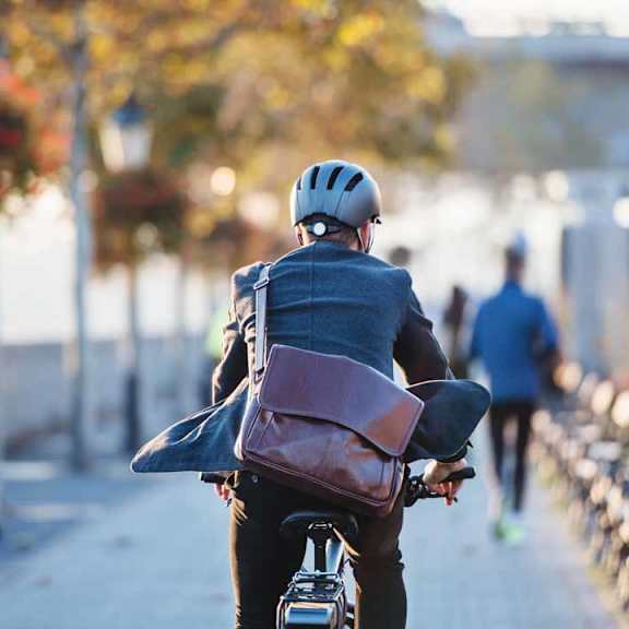 A person is riding a bicycle with a backpack on their back.