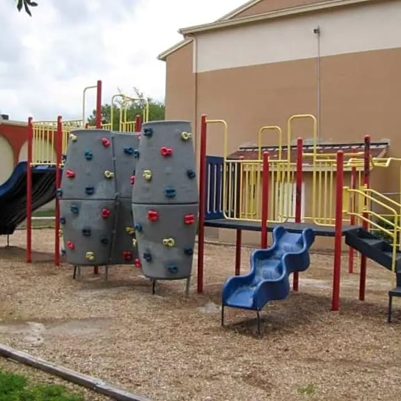 a playground with a bunch of chairs in front of a building at Oak Chase II, Tampa, 33612