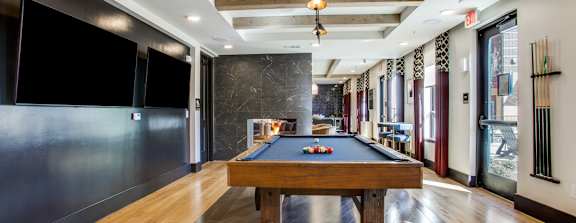 a game room with a pool table and a tv