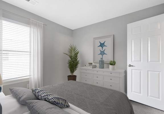A bedroom with a bed, nightstand, and a painting on the wall.